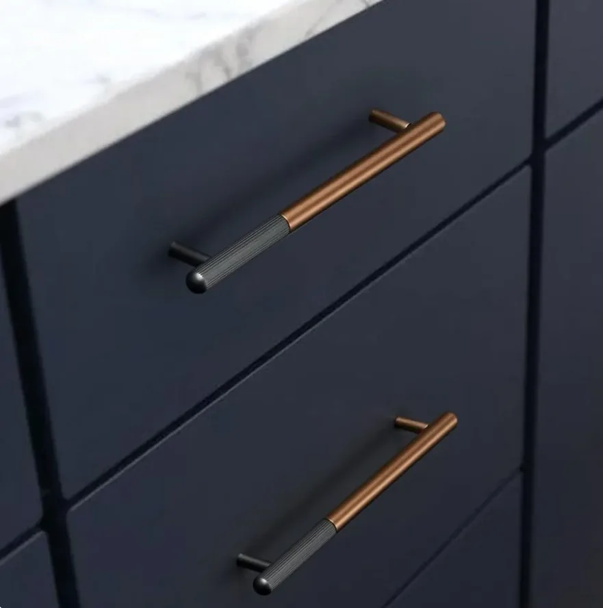 Two-tone black and brass bar pulls on navy kitchen drawers