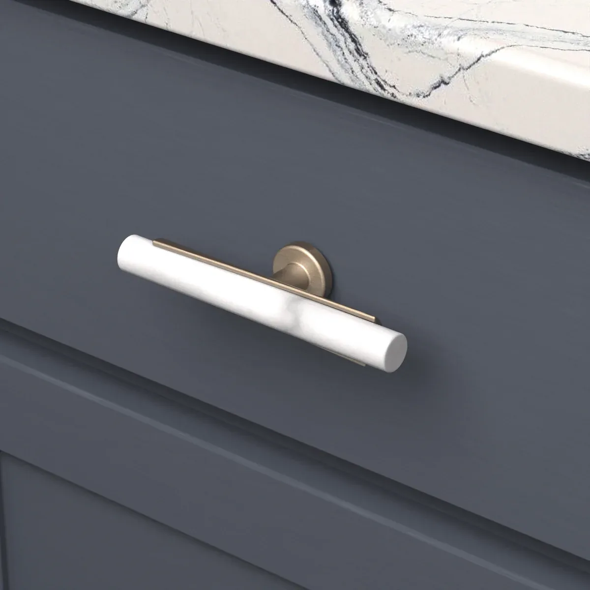 Two-tone brass and white T-knob on a navy cabinet drawer