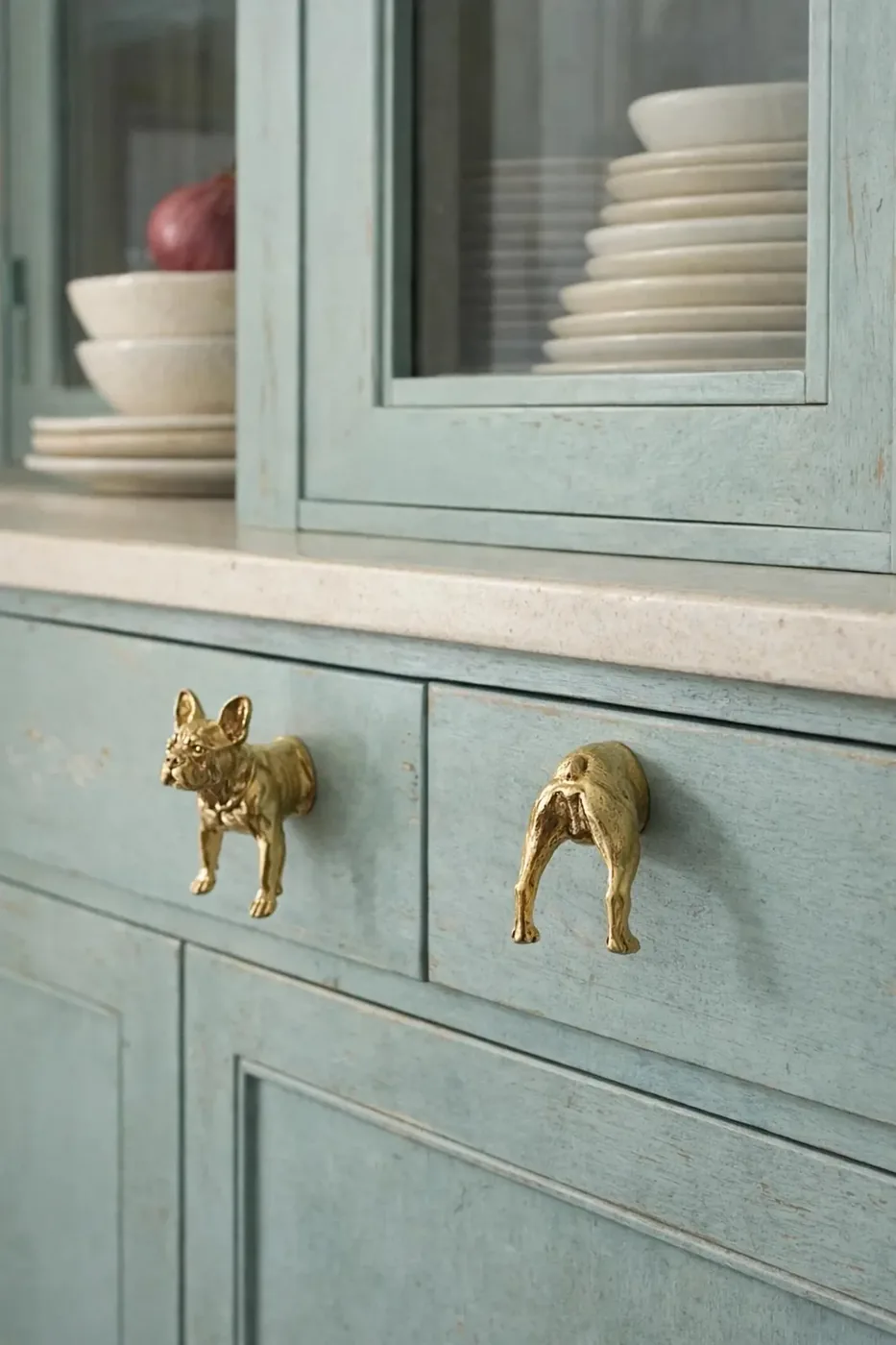 Brass fox-shaped cabinet knobs on sage green cabinetry